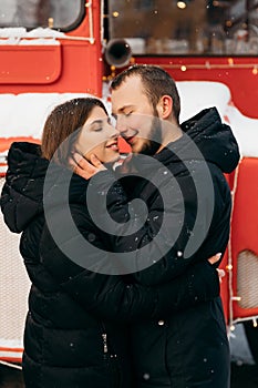 A loving couple hugs on the background of a red bus. Valentine& x27;s Day