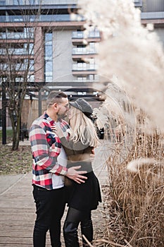 Loving couple kissing outdoor. Cute couple of hipsters is walking in spring park. Beautiful sunny day. Walking on the city`s