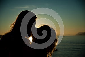 Loving couple kissing in the sunset at the beach