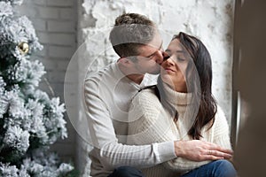 Loving couple on a light background celebrates Christmas. Love, cares, warmth