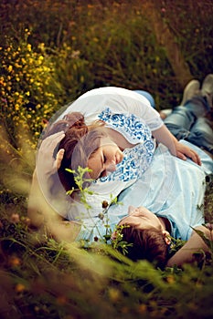 Loving couple lying in the grass in a summer field.