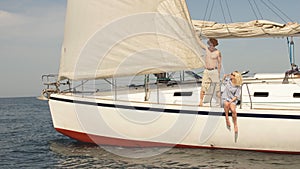 Loving couple lying on yacht at sea. Luxury vacation on seaboat.