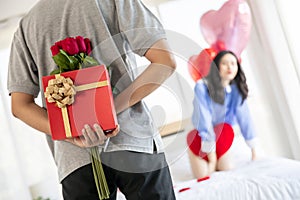 Loving couple  Man with rose and gift on back in bedroom valentines day concept