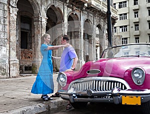 Loving couple near old American retro car (50th years of the last century) on the Malecon street January 27, 2013 in Old Havana,
