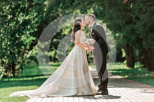 Loving couple of newlyweds standing on a Park alley