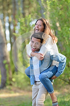 loving couple piggyback in park