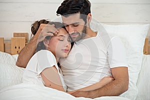 Loving couple relaxing and hugging in bed, love and relationships concept