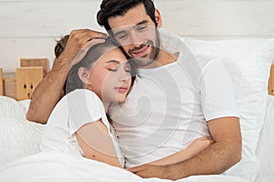 Loving couple relaxing and hugging in bed, love and relationships concept