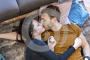 Loving couple is relaxing lying on the floor at home among the suitcases