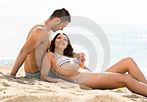 Loving couple relaxing on sand beach