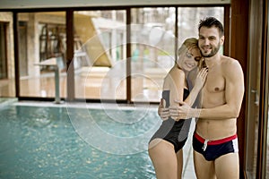 Loving couple relaxing in the spa by the swimming pool