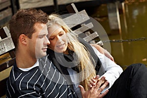 Loving couple resting on bench in park