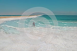 A loving couple is resting on the dead sea. Salt coastline, The sea in Israel dies out and dries up