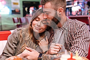 Loving couple in retro bright street food cafe hugging