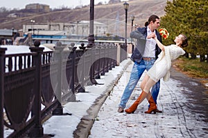 Loving couple on the river bank embraces, kisses