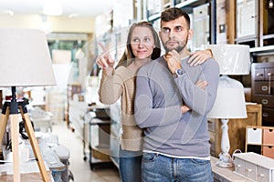 Loving couple in shop of secondhand furniture