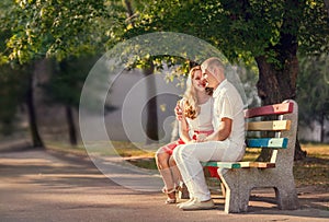 Loving couple sitting on banch in park