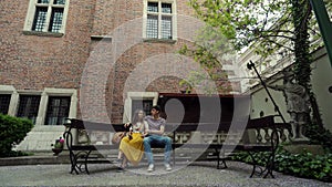 Loving couple sitting on a bench in the Park of the Jagiellonian University