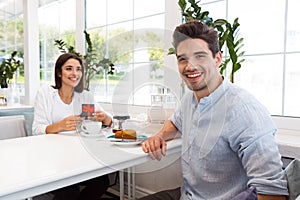 Loving couple sitting in cafe eat desserts and drinking tea