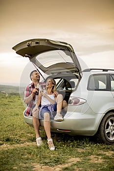 Loving couple sitting in the car trank