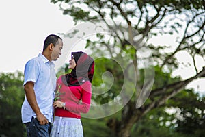 Loving couple sitting down on floral field in park, warm sunny day, enjoying family, romantic date, happiness and love co