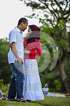 Loving couple sitting down on floral field in park, warm sunny day, enjoying family, romantic date, happiness and love co