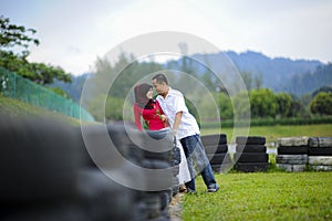 Loving couple sitting down on floral field in park, warm sunny day, enjoying family, romantic date, happiness and love co