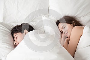 Loving couple sleeping peacefully in comfortable bed, falling as