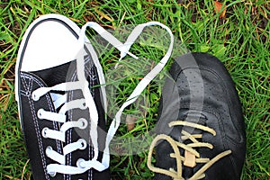 Loving couple sneakers on a background of grass laces in the form of a heart