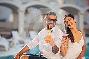 Loving couple spending vacation on tropical resort swimming pool.Newlyweds honeymoon on seaside