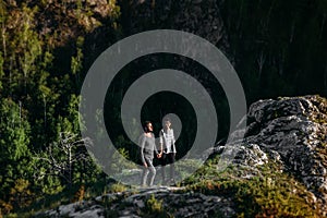 Loving couple at sunset standing on a cliff