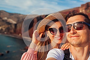 Loving couple takes selfie enjoying honeymoon on Red beach on Santorini island, Greece. Summer vacation