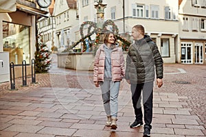 Loving couple of tourists walking around old town. Couple of lovers leisurely stroll in the cool autumn