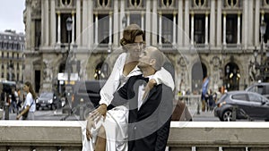 Loving couple video shooting on their wedding day. Action. Bride in white dress and groom in suit on the background of