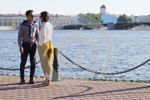 The loving couple walk on embankment of a river `Neva`.