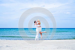 Loving couple walking and embracing on a summer beach