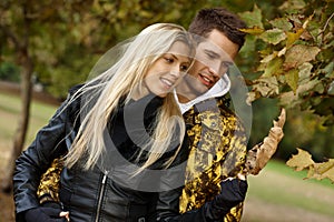 Loving couple walking in park at autumn