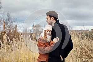 Loving couple walking in Park in autumn hugs and kisses. Autumn