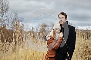 Loving couple walks in the autumn Park, hugs and kisses. Woman i