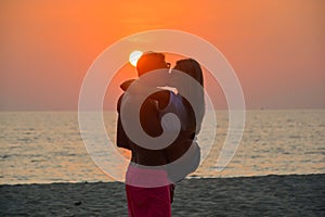 A loving couple watching the sunset on the beach