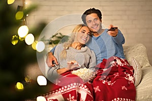 Loving couple watching tv at Christmas eve