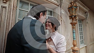 loving couple in wedding day, man is holding and kissing hands of his bride, beautiful woman