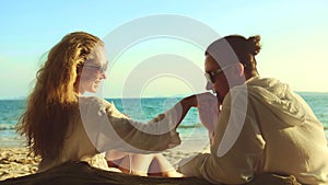 Loving couple in white dress, sunglasses, kissing, relax and drinking cocktail. Concept sea beach resting tropical