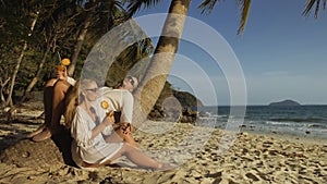 Loving couple in white dress and sunglasses, near palm tree, rel
