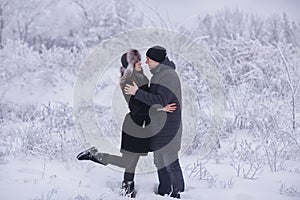 A loving couple on a winter walk. Snow love story, winter magic. Man and woman on the frosty street. The guy and the girl are rest