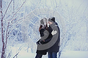 A loving couple on a winter walk. Snow love story, winter magic. Man and woman on the frosty street. The guy and the girl are rest