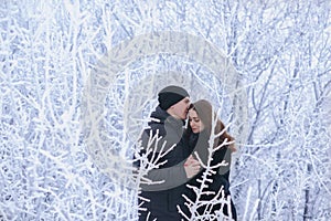 A loving couple on a winter walk. Snow love story, winter magic. Man and woman on the frosty street. The guy and the girl are rest