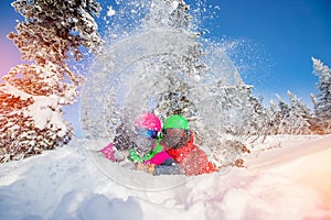 Loving couple woman and man having fun and fooling around in winter forest. Skier and snowboarder on background of blue