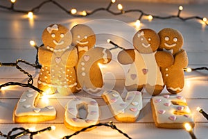 Loving couples of gingerbread men against a background of glowing letters