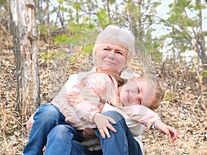 Loving cute granddaughter hugging her grandmother. Happy family.  Having good times with grandparent outdoors